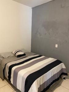 um quarto com uma cama com um cobertor preto e branco em Casa a 5 minutos del mar em Mazatlán