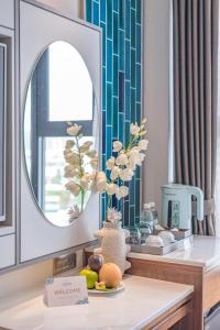 a bathroom with a mirror and a table with fruit at Seaesta Nha Trang Hotel in Nha Trang