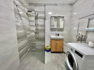 a bathroom with a shower and a washing machine at Apartmani Ana in Dramalj +66 photos