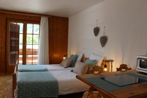 ein Hotelzimmer mit einem Bett, einem Schreibtisch und einem Tisch in der Unterkunft Le Vieux Valais in Ovronnaz