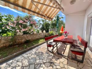a red table and chairs on a patio at Apartmani Ana in Dramalj