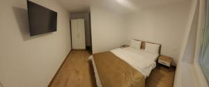 ein kleines Schlafzimmer mit einem Bett und einem Flachbildfernseher in der Unterkunft Casa Vida in Luncasprie