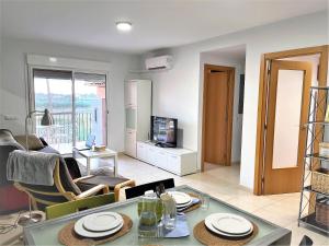 a living room with a table and chairs and a tv at Lo Petit Delta in El Lligallo del Gànguil