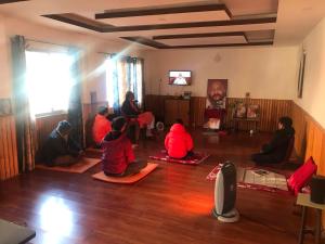 um grupo de pessoas sentadas no chão em uma sala em Osho Gaurishankar Meditation Center em Catmandu