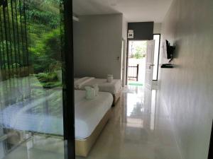 a bedroom with two beds and a glass window at เกาะช้างรักดี รีสอร์ท in Ko Chang