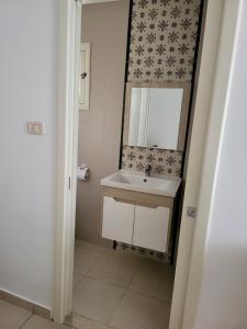Hotel Dar Al Madina في المهدية: حمام مع حوض ومرآة