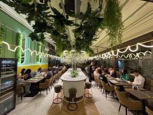 a dining room with people sitting at tables in a restaurant at Renato HOUSE in Târgu Jiu