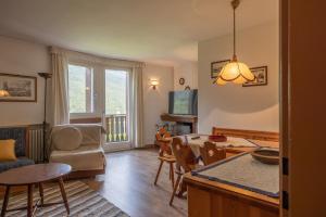 a living room with a kitchen and a dining room at Casa Lino in Borca di Cadore