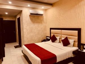 a bedroom with a large bed with a red blanket at Hotel The Onix in Dehradun