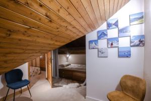 Cette chambre comprend un lit et des photos sur le mur. dans l'établissement Bel appartement entier en style Chalet à Chamonix, à Chamonix-Mont-Blanc