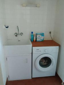 a washing machine and a sink in a bathroom at Jolie villa avec jardin à proximité de la plage in La Brée-les-Bains