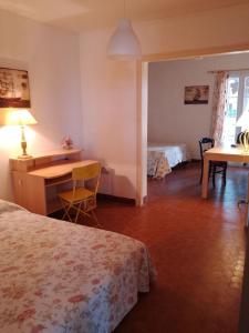 a hotel room with a desk and a bed at Jolie villa avec jardin à proximité de la plage in La Brée-les-Bains