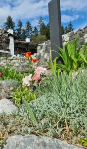 einen Garten mit Blumen und Steinen und ein Schild in der Unterkunft Alpenchalet Zum Jeremia in Grainau