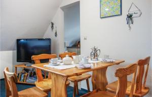 a dining room table with chairs and a television at Nice Apartment In Otterndorf With Kitchen in Otterndorf