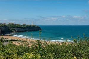 a view of a beach with a lighthouse in the distance at Moana Haven Biarritz - Plages - Golf - WIFI - Standing in Anglet