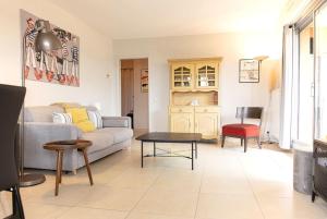 ein Wohnzimmer mit einem Sofa und einem Tisch in der Unterkunft Moana Haven Biarritz - Plages - Golf - WIFI - Standing in Anglet