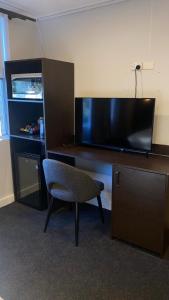 a desk with a chair and a desk with a television at Echo Point Discovery Motel in Katoomba