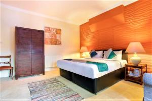 a bedroom with a large bed with a large wooden headboard at Yardley Manor Hotel in Torquay