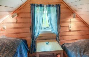a room with a window and a table in a cabin at Stunning Home In Mosvik With House Sea View in Mosvik