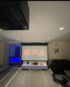 ein Wohnzimmer mit einem Netflix-Schild an der Wand in der Unterkunft #1 Luxury Villa with Pool, Gameroom, Spa, Zen Yard in Belgrad