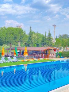 una piscina con sillas y sombrillas y un parque infantil en palm club apart otel, en Kusadasi