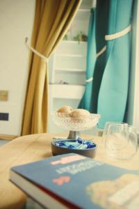 a bowl on a table with a book and glasses at B&B Herenhuis1919 in Lo-Reninge