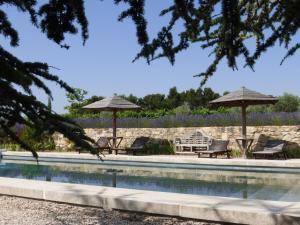 einen Pool mit 2 Sonnenschirmen und Liegestühlen in der Unterkunft Domaine du Coffre in Pertuis