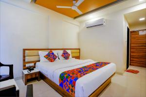 a bedroom with a bed with a colorful blanket at FabHotel Ramjis Residency in Nashik