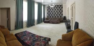 sala de estar con 2 sillas y sofá en Family house, en Tashkent