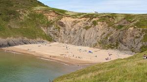 a group of people on a beach next to a cliff at Static 19 in Llandysul