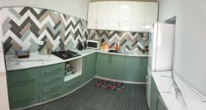 una cucina con mobili verdi e un frigorifero bianco di Family house a Tashkent Altre 8 foto