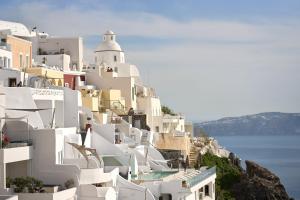 a group of white buildings on the side of a hill at Amphitheater Cave Houses in Fira