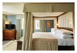 a bedroom with a large bed with a canopy at The Peacock at Rowsley in Great Rowsley