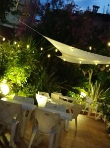 un patio con sillas y una sombrilla blanca por la noche en HOTEL Villa Lilla, en Desenzano del Garda