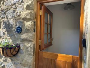 a door to a stone building with a sign on it at The Dale at Greystones - Luxurious annexe with stunning view in Buckden