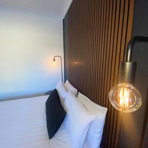 肯图巴Echo Point Discovery Motel的一间卧室配有带白色枕头和灯的床