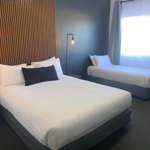 um quarto de hotel com duas camas e uma janela em Echo Point Discovery Motel em Katoomba