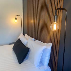 una camera da letto con letto, cuscini e lampada di Echo Point Discovery Motel a Katoomba