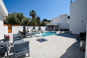 a patio with a swimming pool and lounge chairs and a swimming pool at Swan Boutique Hotel in Bodrum City