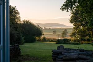 a view of a field with a stone fence at Glen Islay Cottage Himeville in Himeville