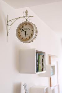 a clock hanging on a wall next to a book shelf at Cozy 2 bedroom apartment close to center in Split