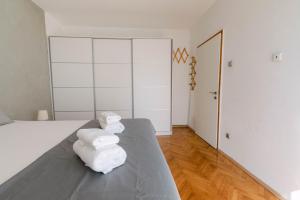 a bedroom with white walls and white towels on a bed at Cozy 2 bedroom apartment close to center in Split