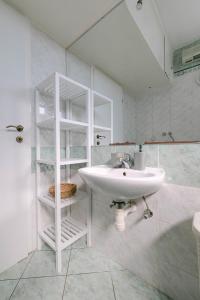 a white bathroom with a sink and a shower at Cozy 2 bedroom apartment close to center in Split