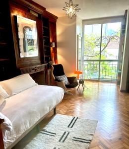 een slaapkamer met een bed, een stoel en een raam bij Niko Rooms in Santa Cruz de Tenerife