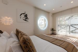 a bedroom with a bed and a large window at Furano Lofts & Chalet in Furano