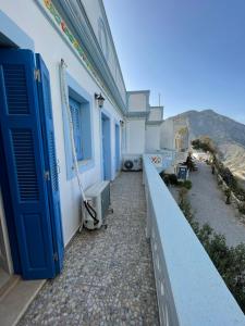 a balcony of a building with a blue door at Hotel THE OLIVE TREE in Olympos