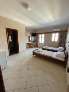 a bedroom with a large bed and a tiled floor at Hotel THE OLIVE TREE in Olympos