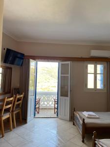 um quarto com uma cama e uma porta de vidro deslizante em Hotel THE OLIVE TREE em Ólympos