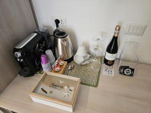 a table with a coffee maker and a bottle of wine at ZAFFIRO'S HOUSE in Cefalù