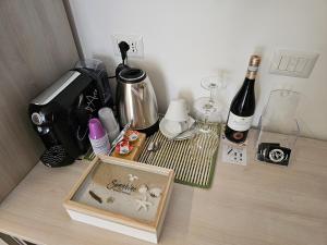 een tafel met een koffiezetapparaat en een fles wijn bij ZAFFIRO'S HOUSE in Cefalù